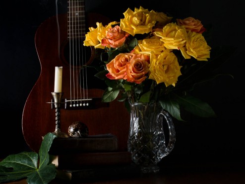 Guitar with candle and yellow roses